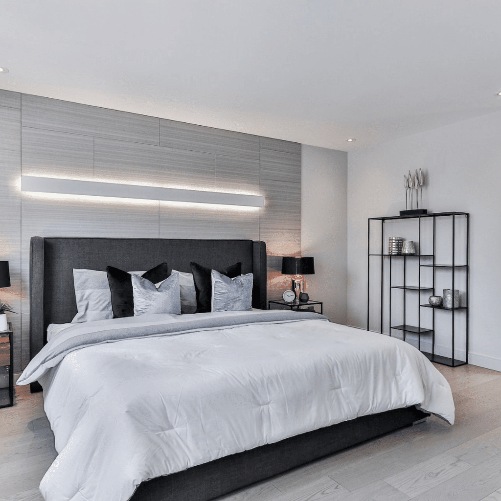 Large bed with light above and grey headboard